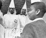 <p>A young African American boy smiles tolerantly at hooded Ku Klux Klansmen as they staged a ìmarchî in downtown Durham, North Carolina, April 24, 1965 preliminary to a mass rally. (Photo: AP) </p>