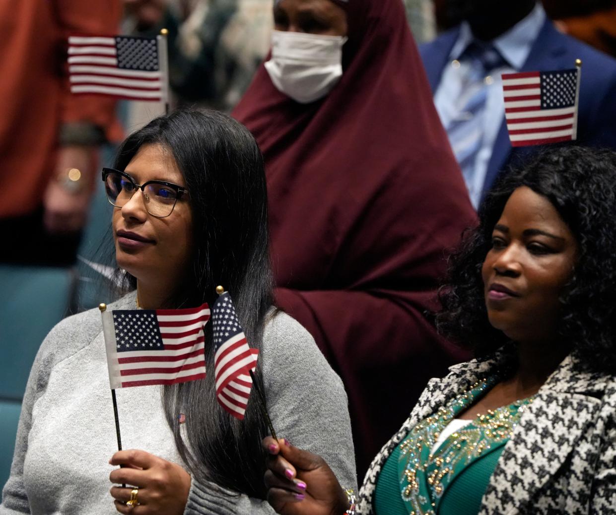 New American citizens wave flags Nov. 17 near the end of a naturalization ceremony at Worthington Kilbourne High School.