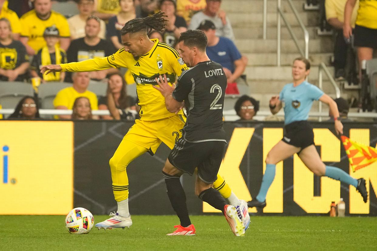 Jul 3, 2024; Columbus, OH, USA; Columbus Crew defender Mohamed Farsi (23) dribbles past Nashville SC defender Daniel Lovitz (2) during the first half of the MLS soccer game at Lower.com Field.