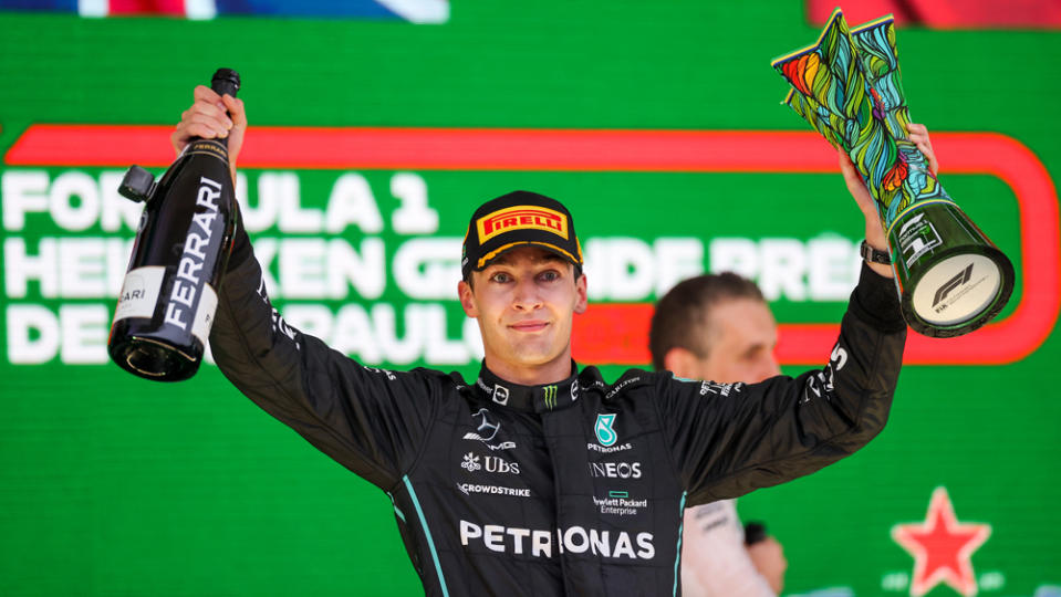 F1 driver George Russell acknowledges the crowd from the podium after he won the 2022 Brazilian Grand Prix.