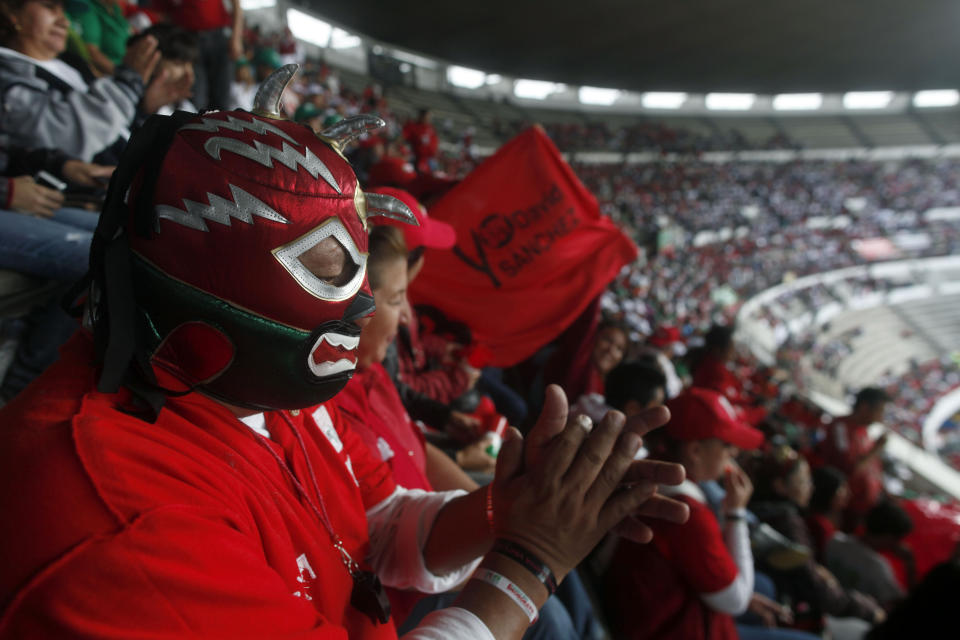 Supporters of Enrique Pena Nieto, presidential candidate of the opposition Institutional Revolutionary Party, PRI, one using a Mexican wrestling mask, cheer during a campaign rally at the Azteca stadium in Mexico City, Sunday, June 24, 2012. General elections in Mexico are scheduled for Sunday, July 1. (AP Photo/Esteban Felix)