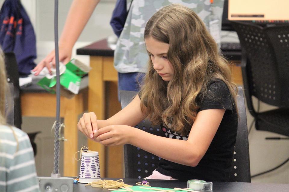 Students in an ExploreHope Summer Science Camp participate in an activity to create a device that can take a core sample from modeling clay.