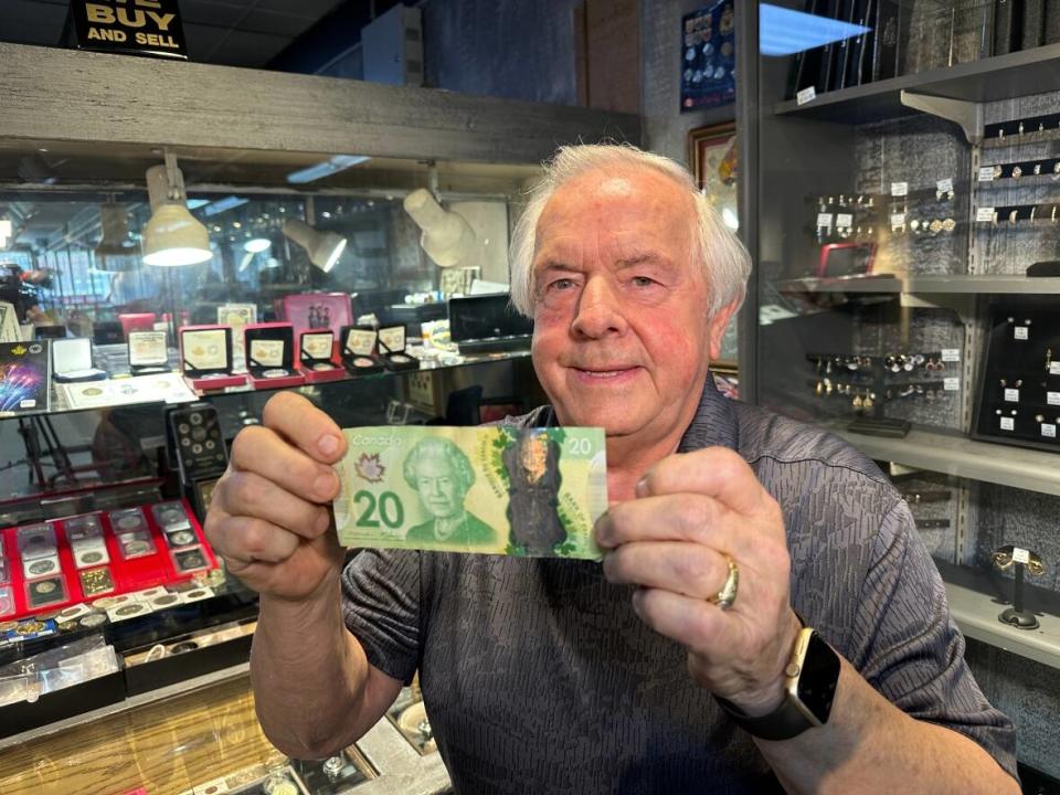 Jerry Ferrari, owner of G and G Jewellery, holds a current Canadian $20 bill. (Dale Molnar/CBC - image credit)