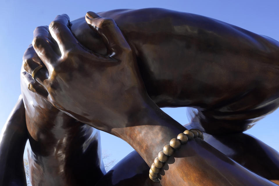 A detail of the 20-foot-high bronze sculpture "The Embrace," shows a hand with a bracelet, Tuesday, Jan. 10, 2023, in the Boston Common, in Boston. The sculpture, a memorial to Dr. Martin Luther King Jr. and Coretta Scott King, consisting of four intertwined arms, was inspired by a photo of the Kings embracing when MLK learned he had won the Nobel Peace Prize in 1964. The statue is to be unveiled during ceremonies Friday, Jan. 13, 2023. (AP Photo/Steven Senne)