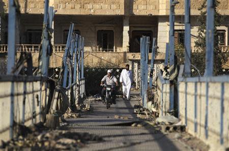 A man rides his motorcycle on the Mohammed Deira bridge in Ahoiqha area in Deir al-Zor August 30, 2013. Picture taken August 30, 2013. REUTERS/Khalil Ashawi