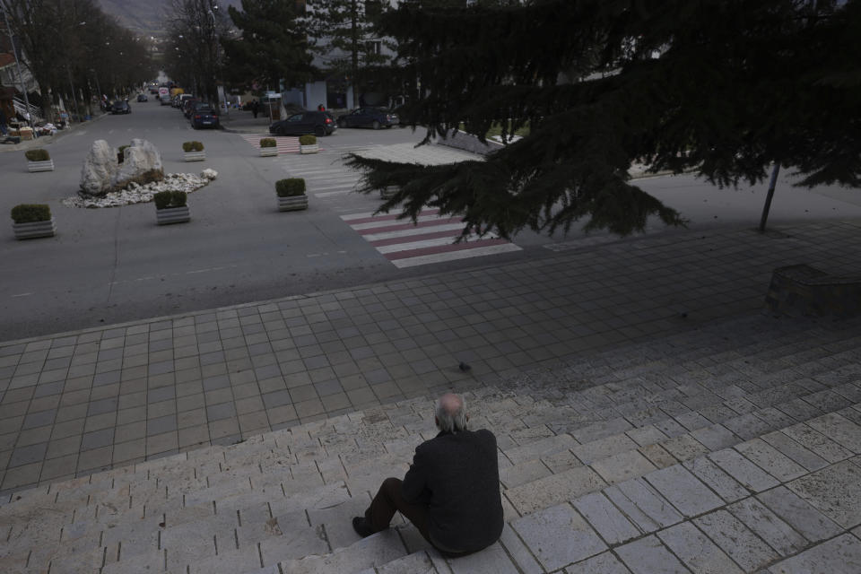 An old man sits in front of the municipality building stairs in Bajram Curri town, 240 kilometers (150 miles) northern of Tirana, Albania, Tuesday, March 14, 2023. Thousands of young Albanians have crossed the English Channel in recent years to seek a new life in the U.K. Their dangerous journey in small boats or inflatable dinghies reflects Albania's anemic economy and a younger generation’s longing for fresh opportunities. (AP Photo/Franc Zhurda)