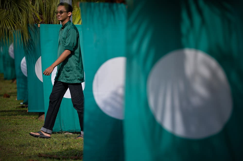 A PAS supporter walks near PAS flags at the 65th Muktamar in Kuantan June 22, 2019. — Picture by Mukhriz Hazim