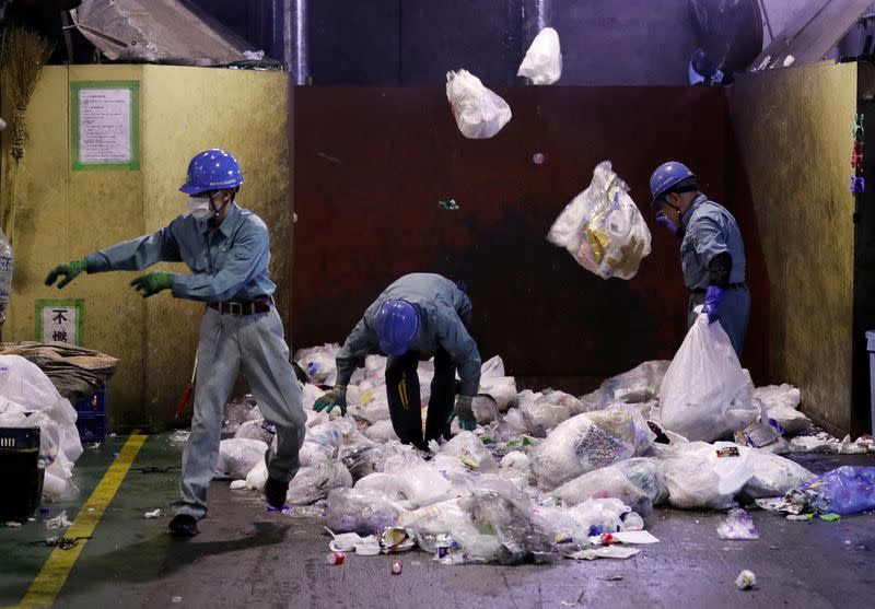 FILE PHOTO: Workers sort out plastic waste for recycling at Minato Resource Recycle Center in Tokyo