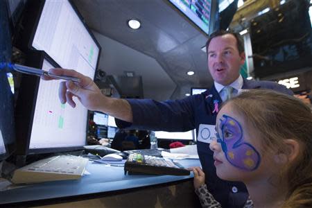 Trader Charles Boeddinghaus makes a trade with his daughter Mallory working at his post on the floor of the New York Stock Exchange November 29, 2013. REUTERS/Brendan McDermid