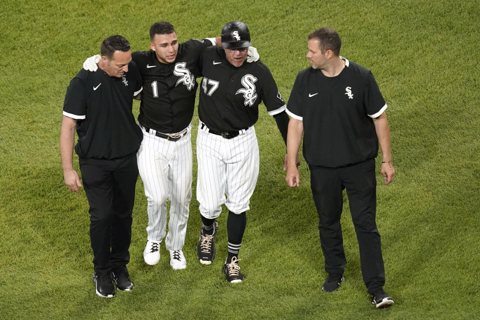 Chicago White Sox's Nick Madrigal (1) favors his right foot as he is helped off the field by third base coach Joe McEwing (47) and members of the medical staff during the seventh inning of the team's baseball game against the Toronto Blue Jays on Wednesday, June 9, 2021, in Chicago. (AP Photo/Charles Rex Arbogast)