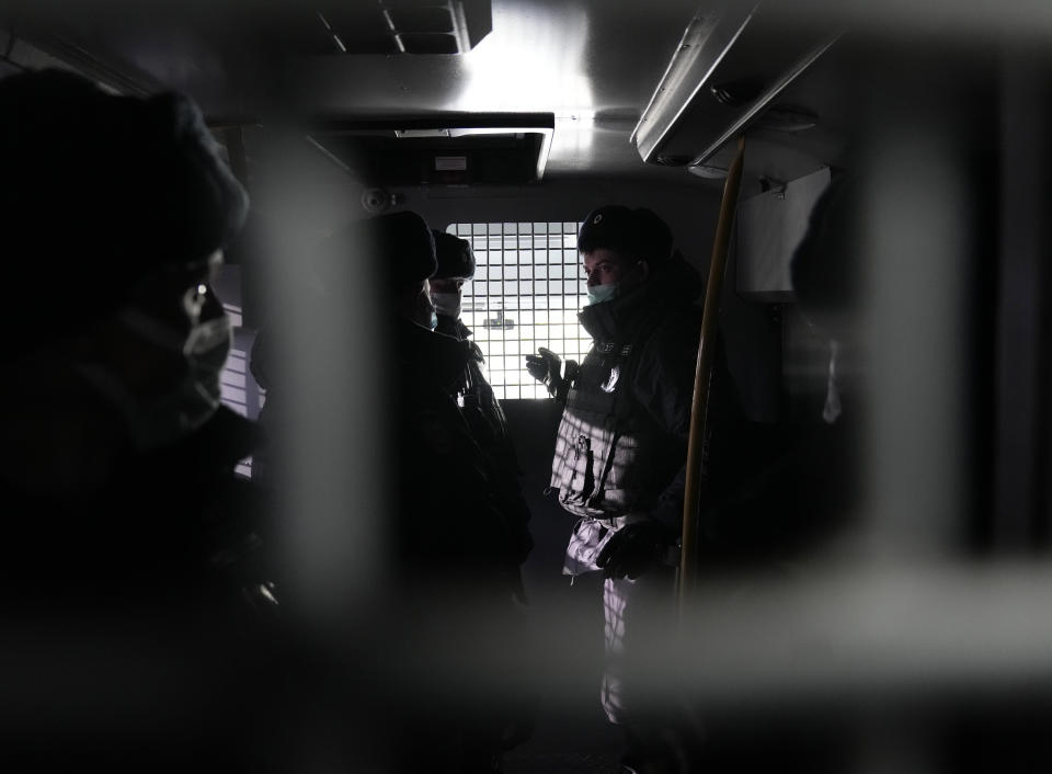 Police officers wearing face masks to help curb the spread of the coronavirus stand inside a police van during an unsanctioned action to mark National Unity Day in Moscow, Russia, Thursday, Nov. 4, 2021. The Moscow authorities banned their traditional "Russian March" in Moscow celebrating People's Unity Day due to the COVID-19 pandemic. (AP Photo/Pavel Golovkin)