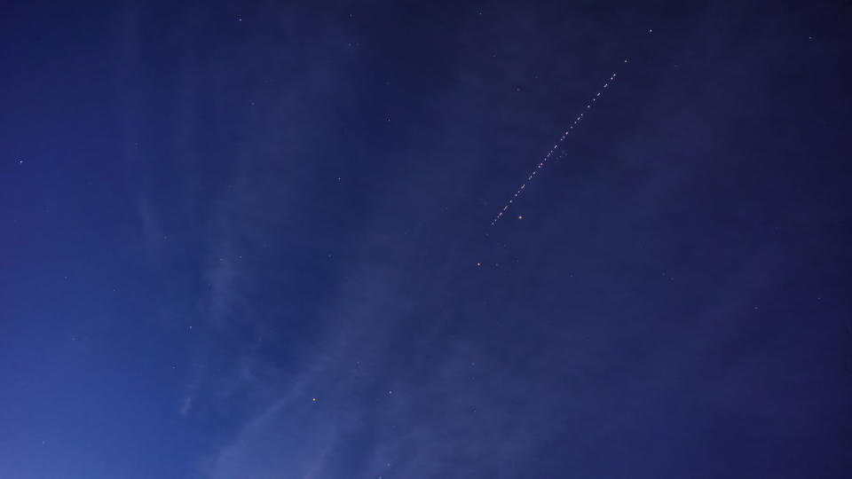 a row of bright dots in a straight line in the night sky