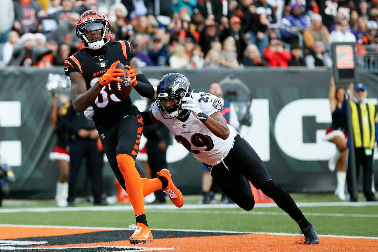 Cincinnati Bengals wide receiver Tee Higgins (85) comes down with a touchdown reception ahead of coverage from Baltimore Ravens safety Ar'Darius Washington (29) in the fourth quarter of the NFL Week 16 game between the Cincinnati Bengals and the Baltimore Ravens at Paul Brown Stadium in downtown Cincinnati on Sunday, Dec. 26, 2021. The Bengals improved to 9-6 on the season with a 41-21 win over the Ravens. 