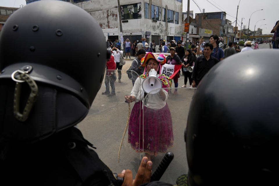 An anti-government protester challenges police surrounding San Marcos University in Lima, Peru, on Jan. 21, 2023. Image: (Martin Mejia / AP)