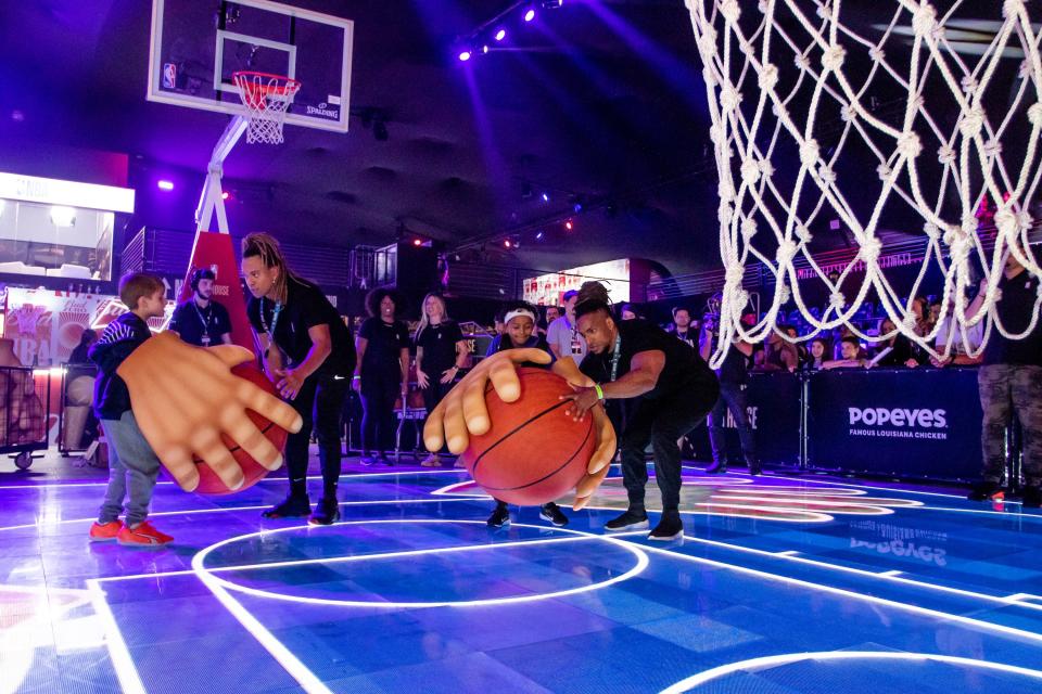 Derick Suzarte (second from right) and another young NBA fan play a game at NBA House, the NBA Finals watch party and immersive experience in Brazil.