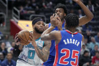 Charlotte Hornets forward Miles Bridges (0) is defended by Detroit Pistons guard Marcus Sasser (25) and center James Wiseman during the first half of an NBA basketball game, Monday, March 11, 2024, in Detroit. (AP Photo/Carlos Osorio)