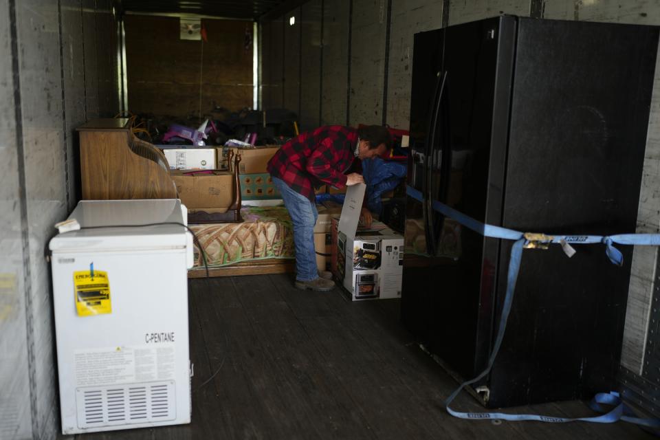 Ron Caetano abre una caja en un tráiler donde colocó las pertenencias de su familia como medida de precaución en caso de inundaciones, en Lemoore, California, el miércoles 19 de abril de 2023. (AP Foto/Jae C. Hong)