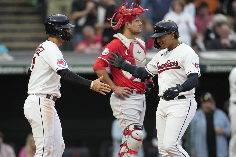 Cleveland Guardians' Bo Naylor, right, celebrates his home run with Andres Gimenez, left, as Cincinnati Reds catcher Luke Maile waits during the second inning of a baseball game Tuesday, Sept. 26, 2023, in Cleveland. (AP Photo/Sue Ogrocki)