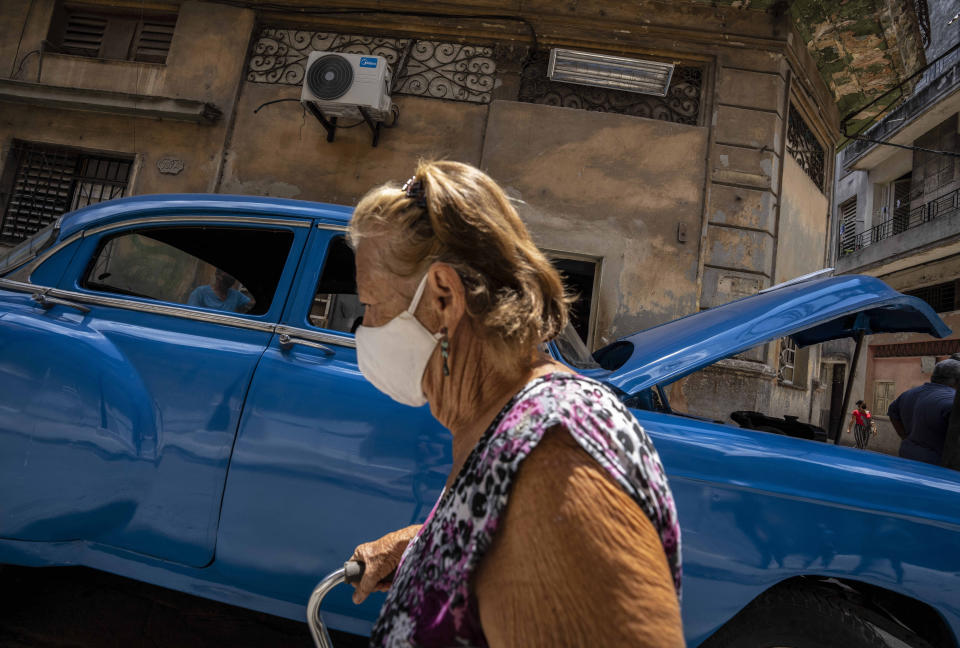 A woman, wearing a protective face mask as a precaution against the spread of the new coronavirus, walks past in Havana, Cuba, Wednesday, June 2, 2021. (AP Photo/Ramon Espinosa)