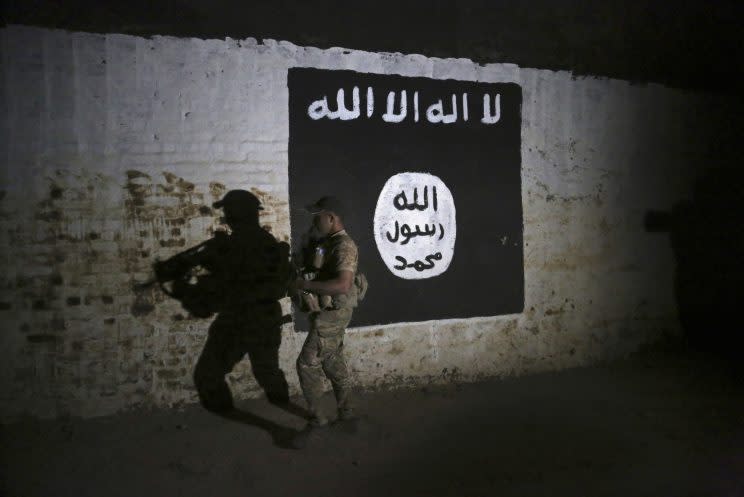 A soldier near an Islamic State flag in Iraq (Rex)