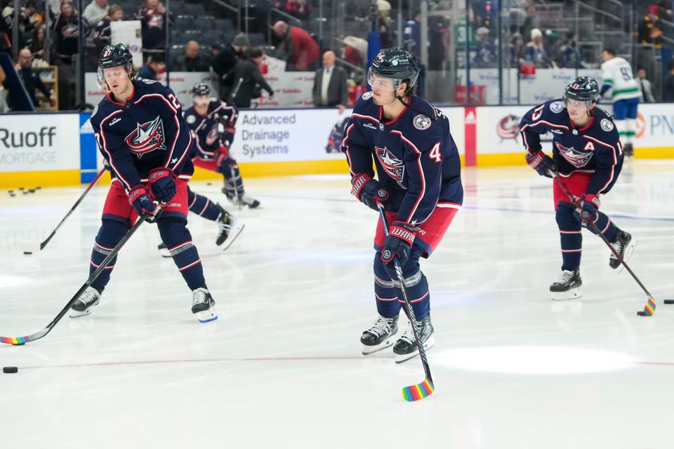 Jan 15, 2024; Columbus, Ohio, USA; From left, Columbus Blue Jackets defenseman Adam Boqvist (27), center Cole Sillinger (4) and left wing Johnny Gaudreau (13) warm up with pride tape on their sticks on Hockey Is For Everyone day at the NHL hockey game against the Vancouver Canucks at Nationwide Arena.