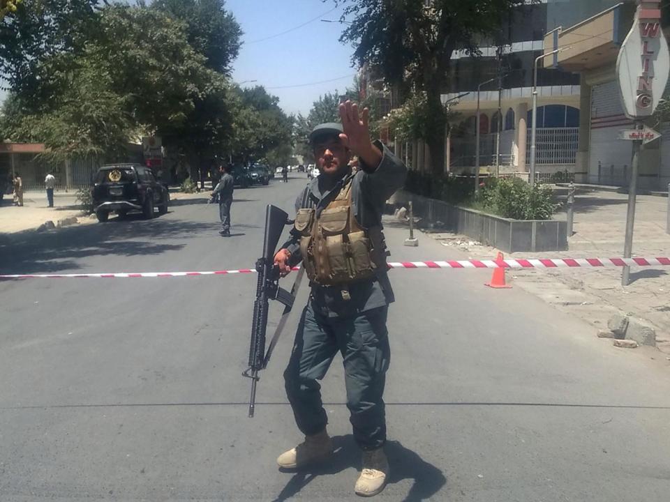 An Afghan policeman sets up a perimeter at the site of the explosion in Kabul (AFP)