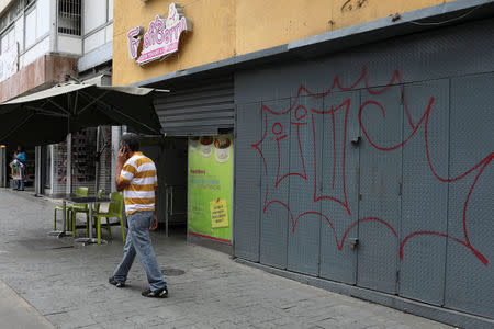 A man walks past reinforced security gates at a store in downtown Caracas, Venezuela January 16, 2018. Picture taken January 16, 2018. REUTERS/Marco Bello