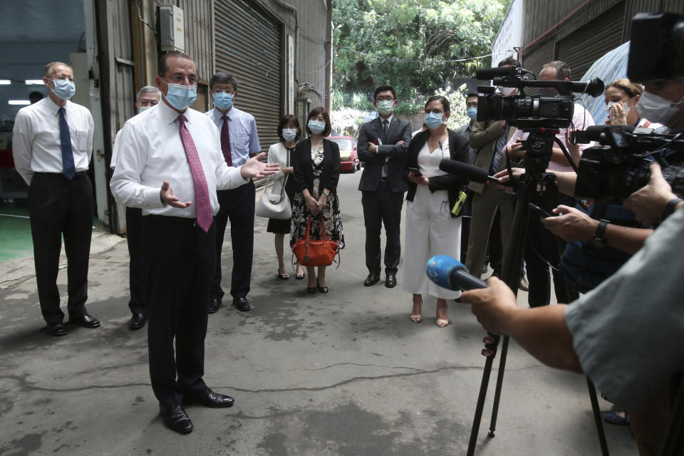 U.S. Health and Human Services Secretary Alex Azar, second from left, answers to the media after visiting a mask factory in New Taipei City, Taiwan, Wednesday, Aug. 12, 2020. Wednesday is the last day of Azar's schedule during the highest-level visit by an American Cabinet official since the break in formal diplomatic ties between Washington and Taipei in 1979. (AP Photo/Chiang Ying-ying)