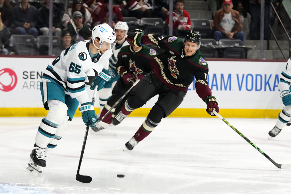 San Jose Sharks defenseman Erik Karlsson (65) passes the puck in front of Arizona Coyotes center Nick Bjugstad (17) during the first period of an NHL hockey game in Tempe, Ariz., Tuesday, Jan. 10, 2023. (AP Photo/Ross D. Franklin)