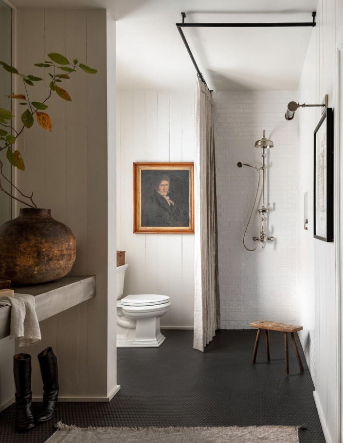 Large wall-mounted artworks and sculptural vaseadd a splash of personality to this Sean Anderson-designed bathroom.