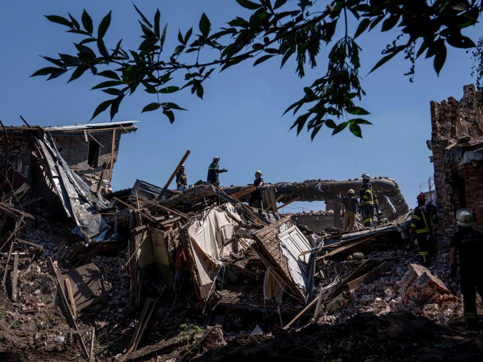 Rescue workers clear rubble of a destroyed house in Kharkiv (AP)