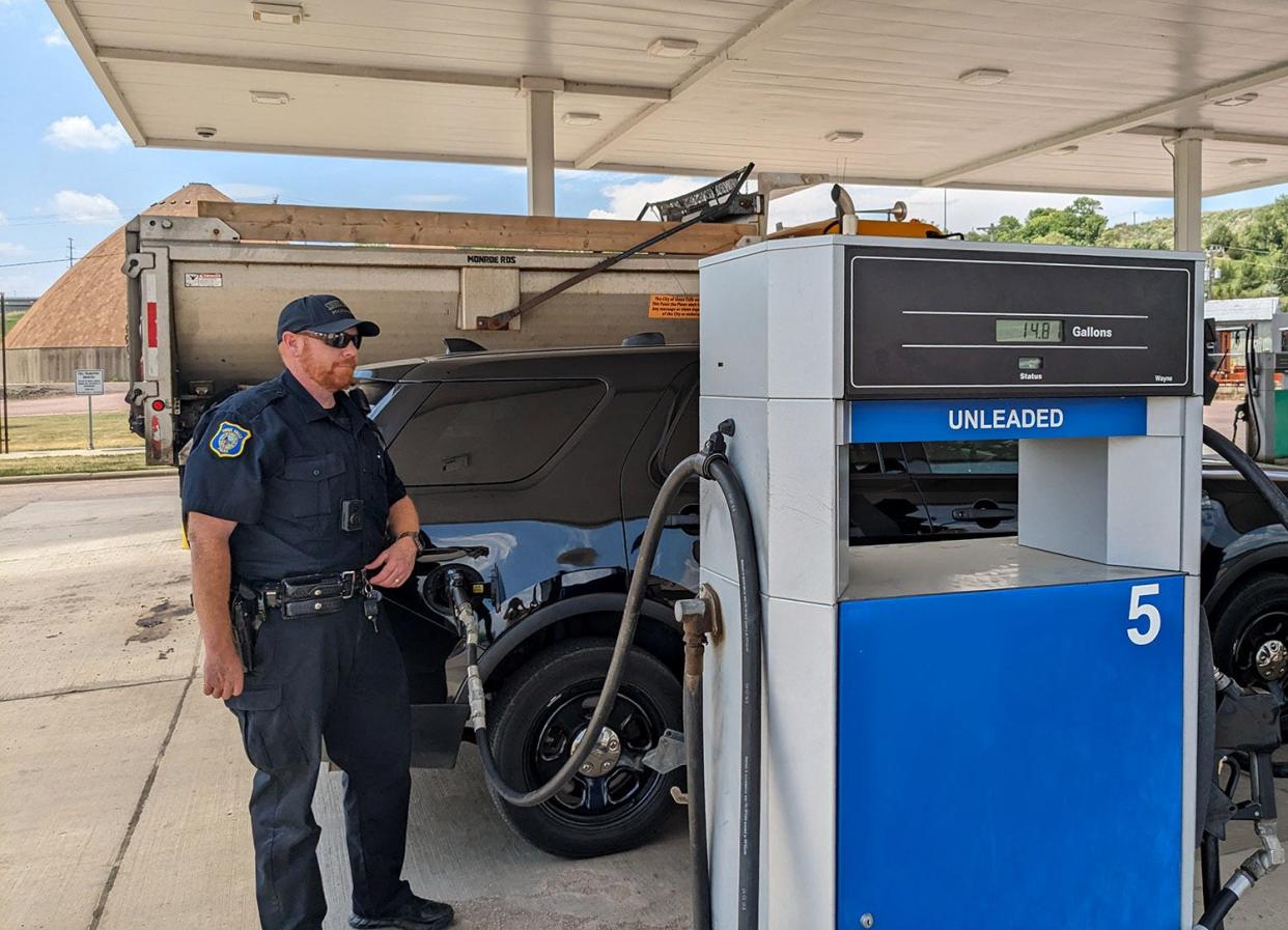 Officer Aaron Klein of the Sioux Falls Police Department fuels up at a Street Department facility on June 22, 2023.