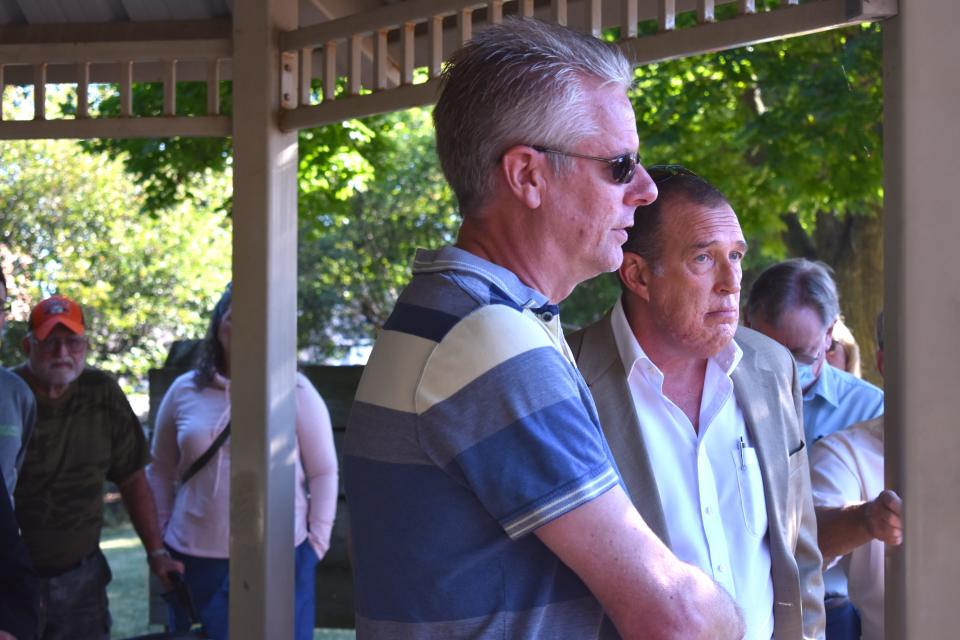 Scott Beltz, chief executive officer of Medallion Management Inc. of Kalamazoo, left, and Adrian City Administrator Greg Elliott address a crowd gathered July 29 at Comstock Park in Adrian regarding the future of the condemned Riverview Terrace apartment building.