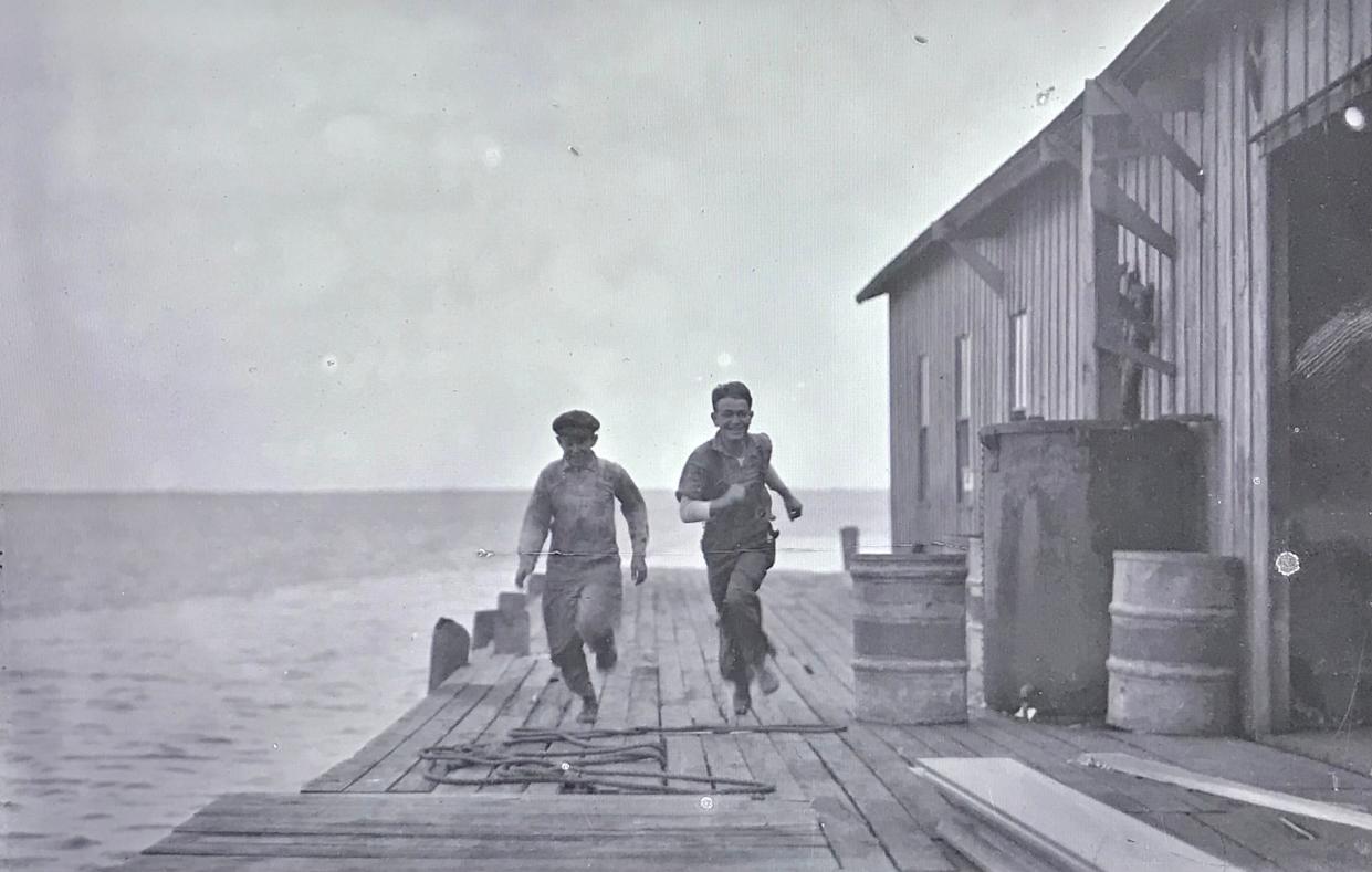 David Alexander, left, and Todd Backus are pictured running along the Peterson fish house dock in Fort Piece, late 1930s.