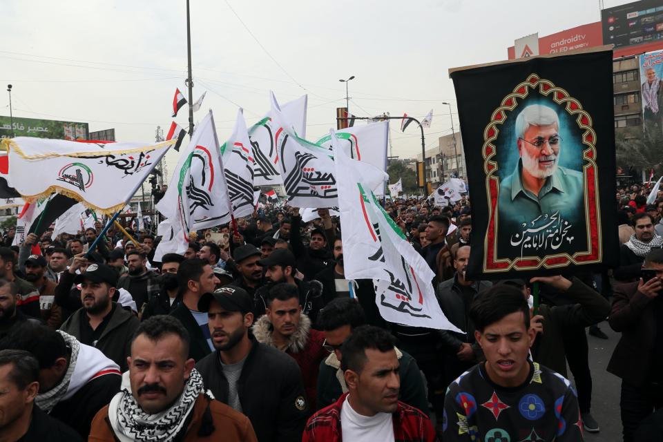 Supporters and members of the Popular Mobilization Forces chant slogans in Baghdad, Iraq, Saturday, Jan. 1, 2022. Hundreds rally in Baghdad on Soleimani assassination anniversary, chanting anti-American slogans, hundreds of people rallied in in the Iraqi capital on the first day of the year Saturday to mark the anniversary of the killing of a powerful Iranian general and a top Iraqi militia leader in a U.S. drone strike. (AP Photo/Khalid Mohammed)