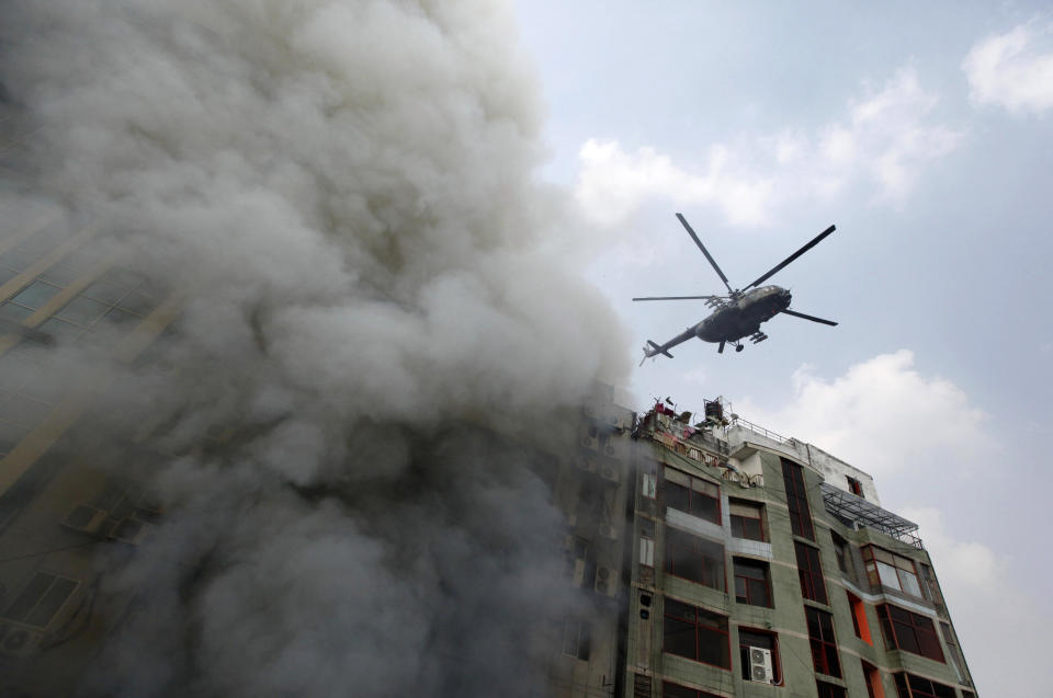 A chopper hovers to evacuate people stuck in a multi-storied office building that caught fire in Dhaka, Bangladesh, March 28, 2019. (AP Photo/Mahmud Hossain Opu )