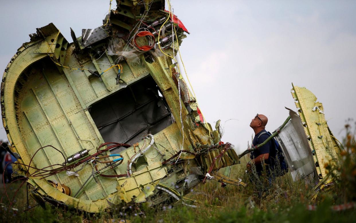 A Malaysian air crash investigator inspects the wreckage of the plane, which had 298 passengers and crew members on board - REUTERS