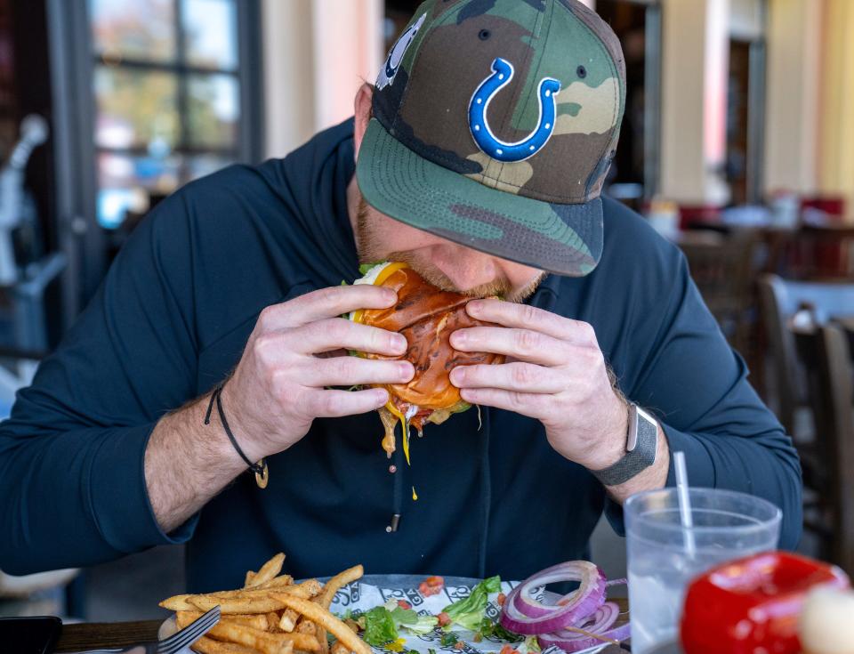 IndyCar Series driver Conor Daly downs a Model “A” burger, locally named for him at Ford’s Garage in Noblesville, Monday, Oct 23, 2023.