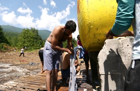 Migrants wash clothes at the migrant camp Vucjak in Bihac area