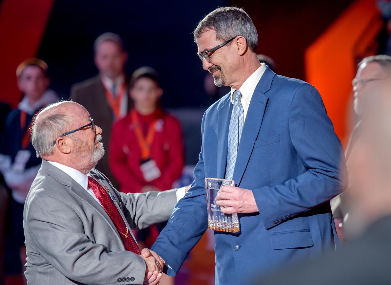 Former PORTA wrestling coach Jeff Hill accepts an award from the IHSA during the Grand March ceremony before the start of the IHSA State Wrestling Championships on Saturday, Feb. 17, 2024 at the State Farm Center in Champaign.