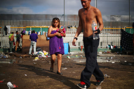 Migrants, part of a caravan of thousands from Central America trying to reach the United States, walk through a temporary shelter in Tijuana, Mexico, November 28, 2018. REUTERS/Hannah McKay