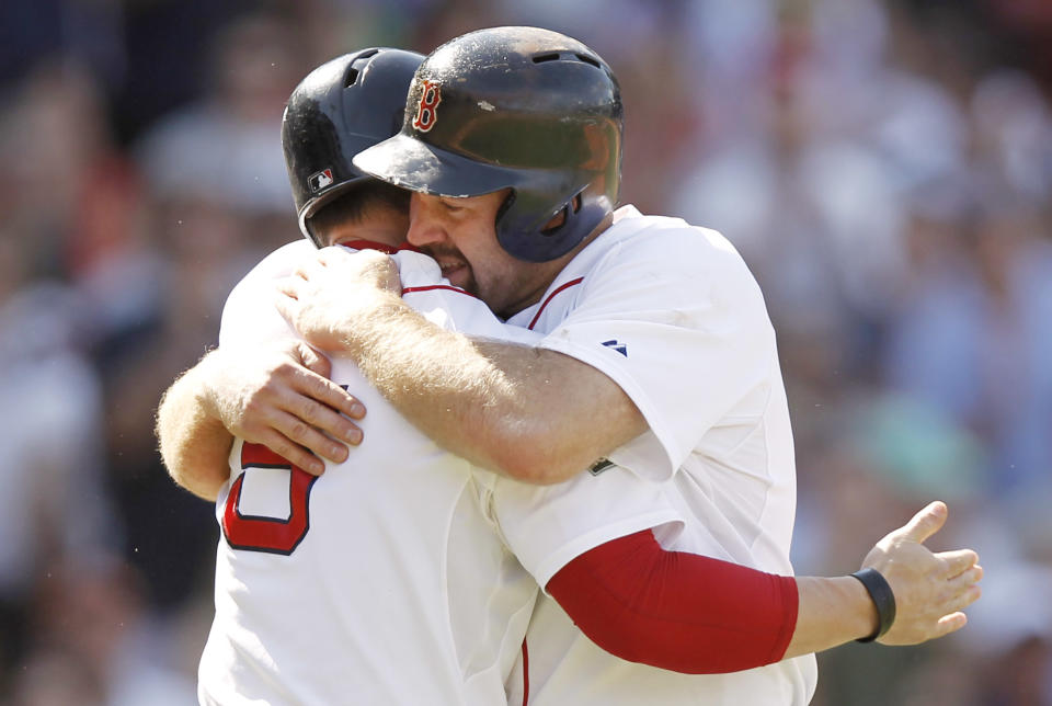 Kevin Youkilis #20 of the Boston Red Sox is hugged by his replacement at third base Nick Punto #5 after he was removed from the game after tripling against the Atlanta Braves during the eighth inning of Boston's 9-4 win in an interleague game at Fenway Park on June 24, 2012 in Boston, Massachusetts. (Photo by Winslow Townson/Getty Images)