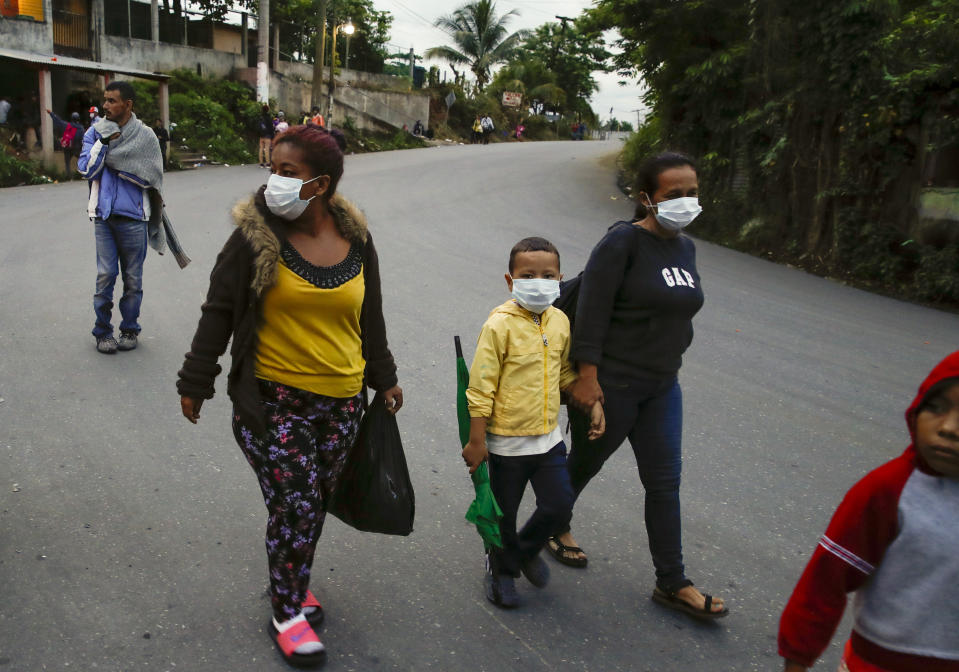 Migrantes hondureños caminan en Puerto Barrios, Guatemala, el viernes 2 de octubre de 2020. Unos 2.000 migrantes hondureños que esperaban llegar a Estados Unidos entraron a Guatemala a pie el jueves, pero el presidente guatemalteco Alejandro Giammattei prometió detenerlos y devolverlos a su país de origen diciendo que representan una amenaza para la salud en medio de los esfuerzos por contener la pandemia de coronavirus. (AP Foto/Moises Castillo)