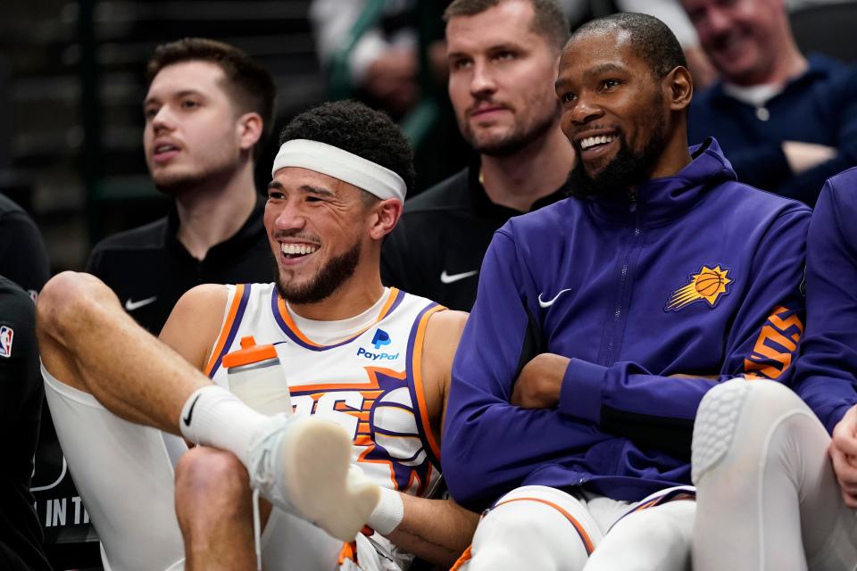 (L-R) Devin Booker #1 and Kevin Durant #35 of the Phoenix Suns watch the second half of the game against the Dallas Mavericks from their bench at American Airlines Center on Jan. 24, 2024 in Dallas, Texas.