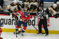 Boston Bruins defenseman Charlie McAvoy (73) and Washington Capitals left wing Carl Hagelin (62) try to get untangled with the help of linesman Devin Berg (87) during the second period of Game 2 of an NHL hockey Stanley Cup first-round playoff series Monday, May 17, 2021, in Washington. (AP Photo/Alex Brandon)