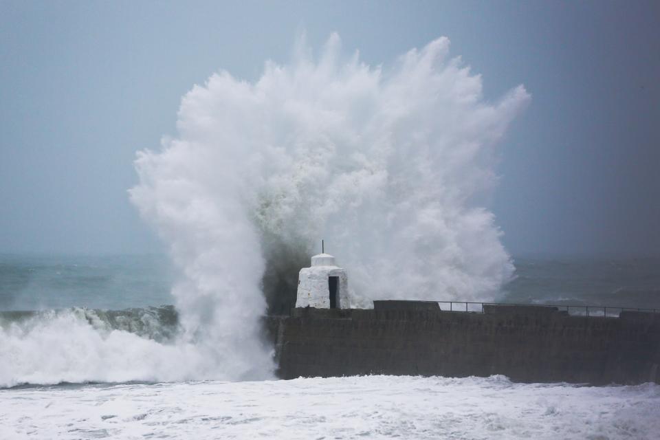 Waves pound against the harbour wall at Portreath in Cornwall in 2020 (PA) (PA Archive)