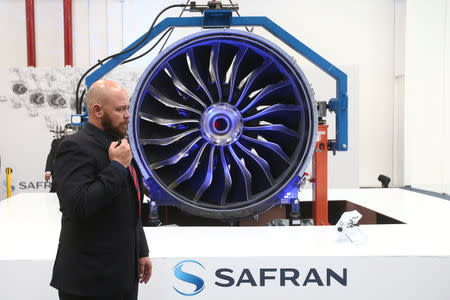 A security guard speaks into a microphone in front of an airplane engine during the inauguration of the Safran Aircraft Engines plant in Queretaro, Mexico, February 21, 2018. REUTERS/Edgard Garrido