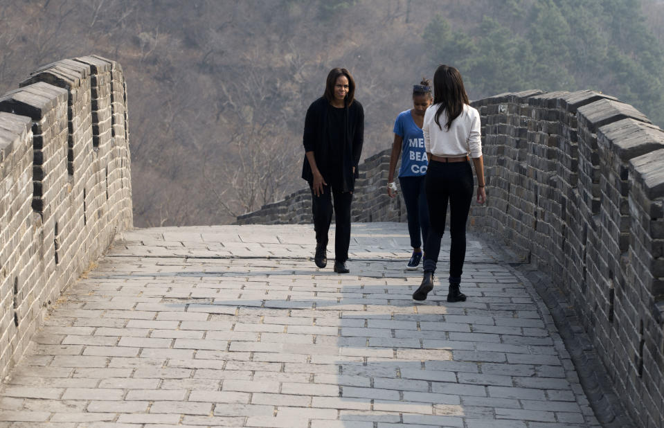 U.S. first lady Michelle Obama, left, walks with her daughters Malia, front, and Sasha as they visit the Mutianyu section of the Great Wall of China in Beijing Sunday, March 23, 2014. (AP Photo/Andy Wong)