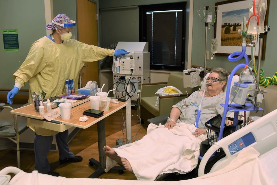 At Lansing's Sparrow Hospital, nurse Maddie Schrauben cares for COVID-19 patient Annette Cyphert, 63 in April 2021.