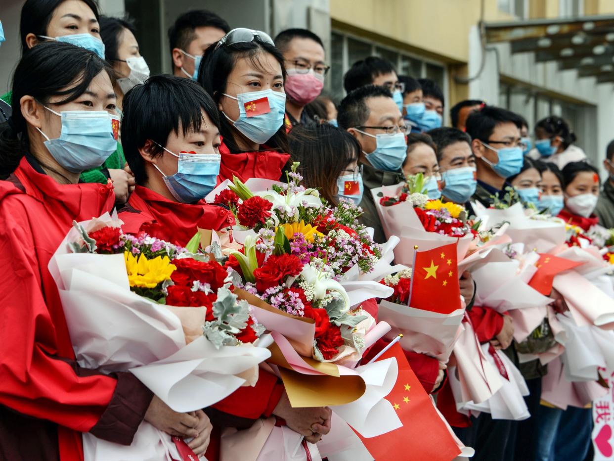 Medical staff member pose for a group photo after returning home from Wuhan helping with the COVID 19 coronavirus recovery effort, in Bozhou, in China's eastern Anhui province on April 10, 2020. STR:AFP via Getty Images)